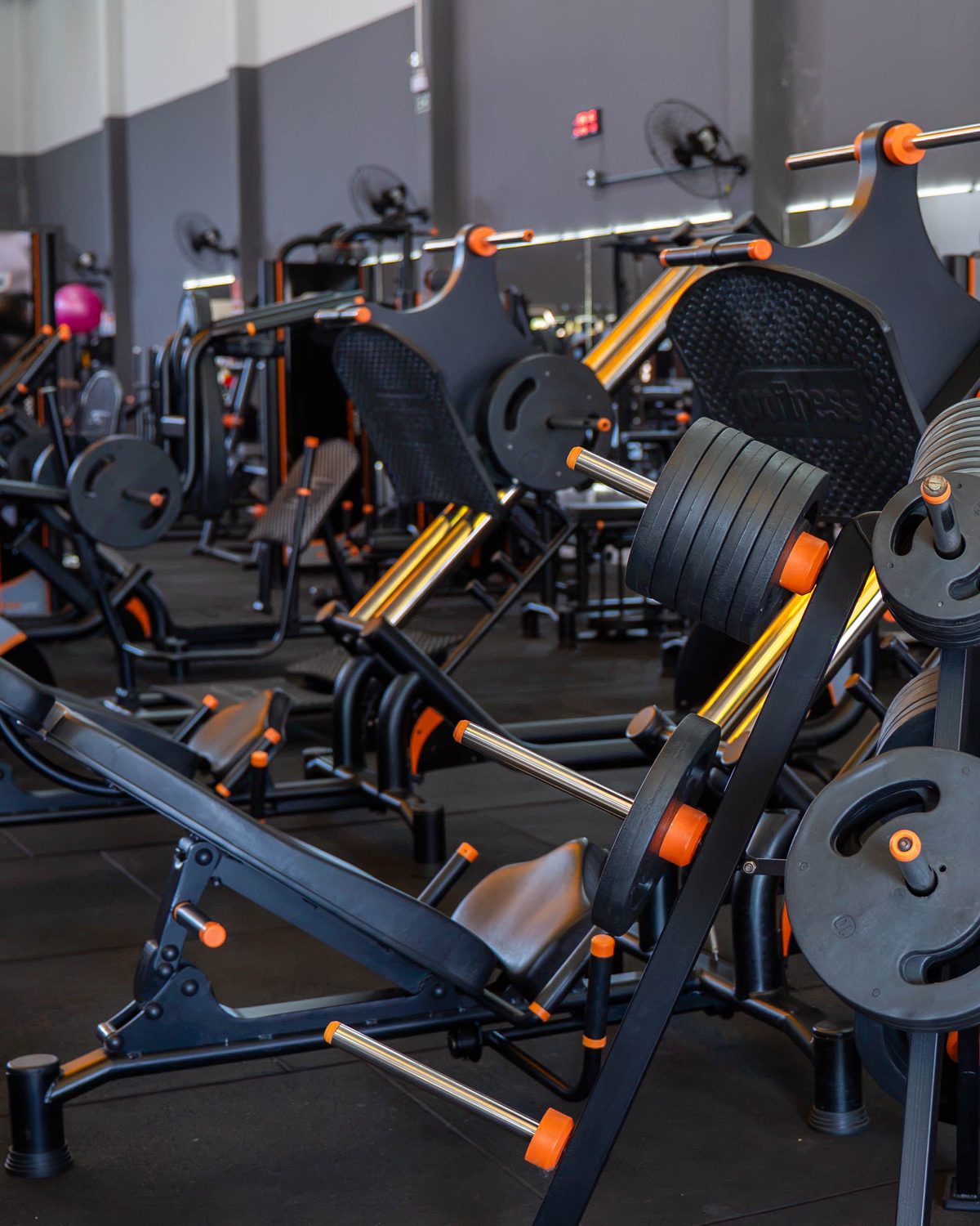 Aparelhos de musculação da Sparta Gym, pretos com detalhes laranja