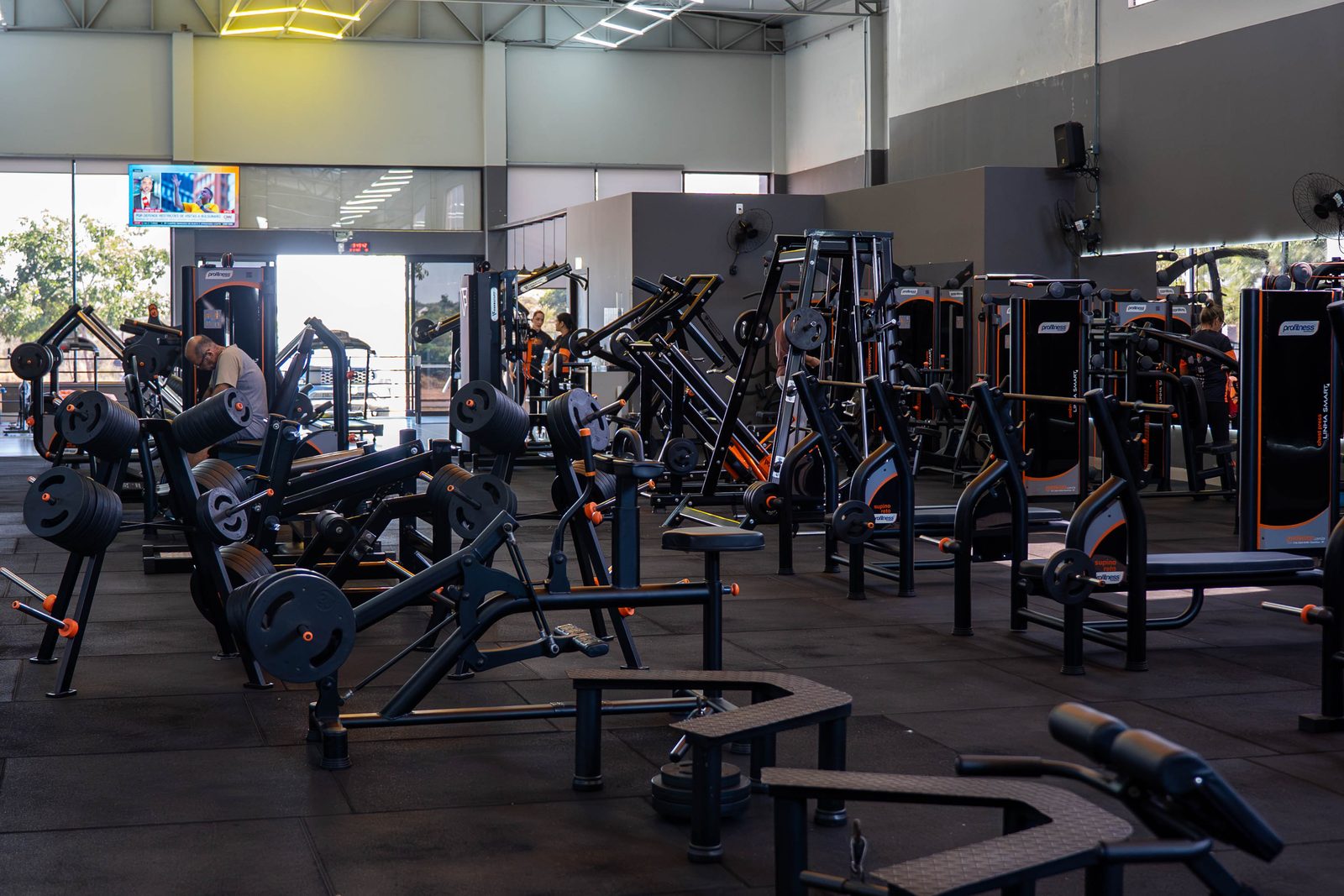 Salão de musculação da Sparta Gym com os aparelhos pretos e laranja